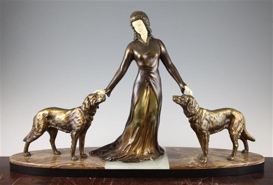 A French Art Deco patinated metal and ivorine figure group of a standing female and two attendant dogs, 25.5in.